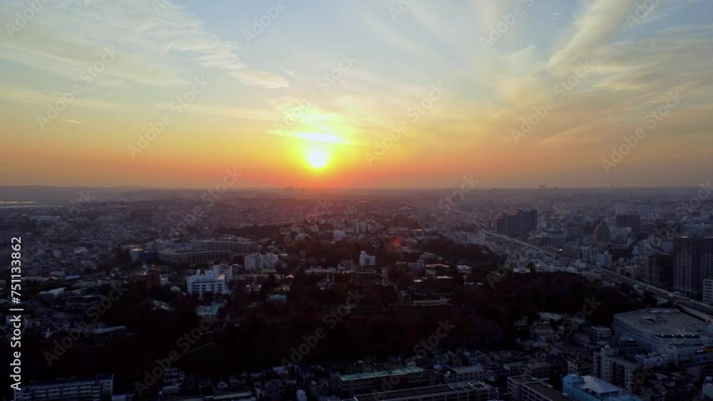 A city skyline at sunset with radiant sun casting hues of orange and blue, aerial view A city skyline at sunset with radiant sun casting hues of orange and blue, aerial view