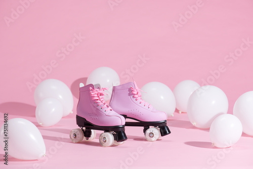 Pair of bright stylish roller skates on pink background photo