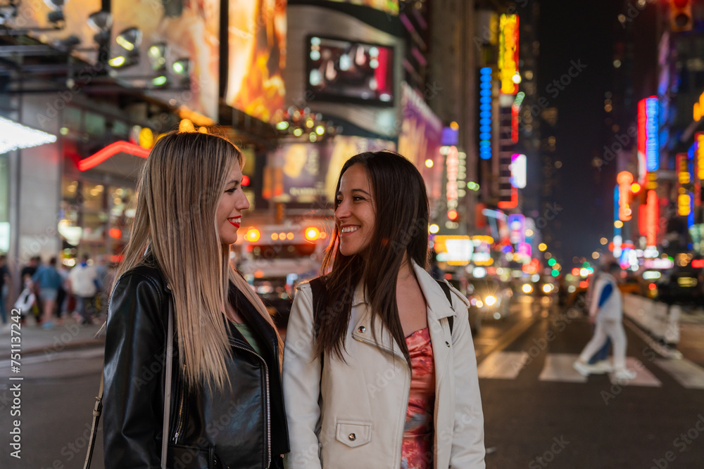 Two Happy Girls Walking In New York At Night. Two Happy Girls Walking In New York At Night.