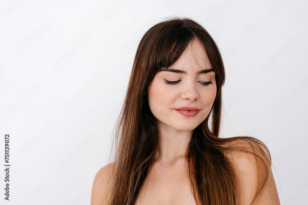 Happy woman in makeup and with long hair near gray wall Happy woman in makeup and with long hair near gray wall