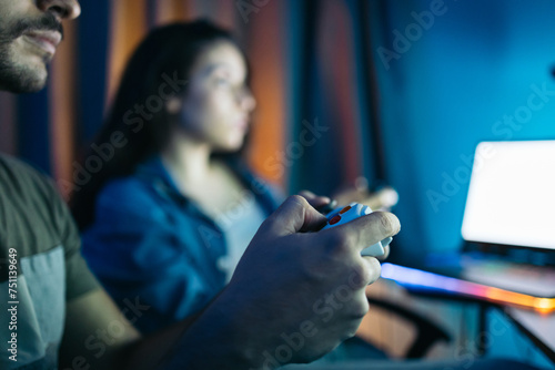 Couple playing video games together in the room photo