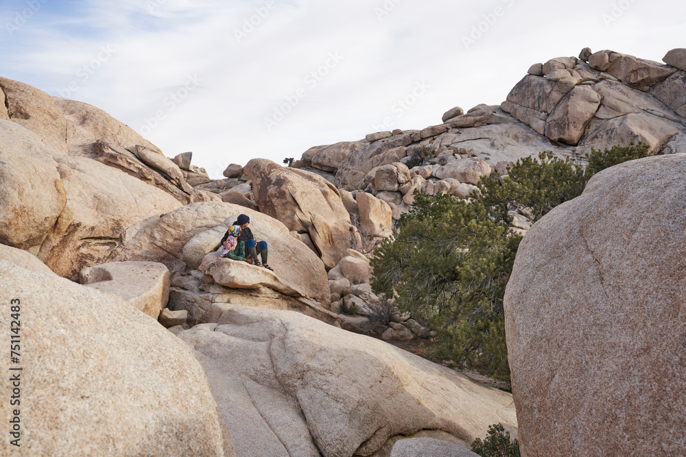 Father and son sitting amongst boulders in Joshua Tree National Park Father and son sitting amongst boulders in Joshua Tree National Park