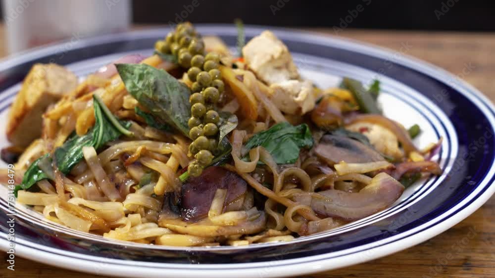Traditional plated tofu Pad Kee Mao plated with fresh basil leaves and sprig of green peppercorns, slider close up 4K Traditional plated tofu Pad Kee Mao plated with fresh basil leaves and sprig of green peppercorns, slider close up 4K
