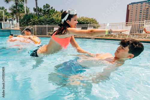 A preteen sister is attempting to hit her teen brother.  photo