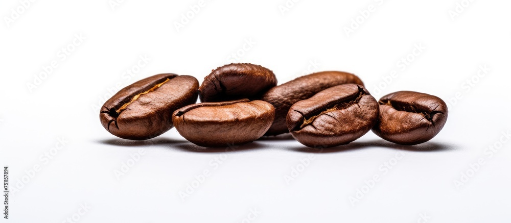 A close-up shot of a pile of dark brown coffee beans resting on top of a white table. The beans appear freshly roasted and exude an enticing aroma, highlighting the energizing caffeine they contain. A close-up shot of a pile of dark brown coffee beans resting on top of a white table. The beans appear freshly roasted and exude an enticing aroma, highlighting the energizing caffeine they contain.