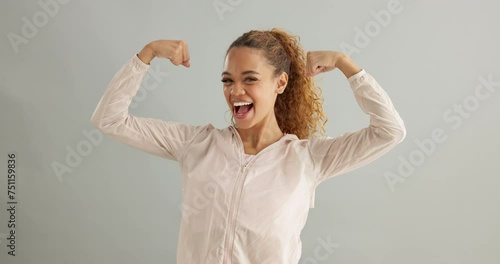 Happy, face and woman with arm flex in studio for success, celebration or victory on grey background. Excited, portrait and female model with power pose for empowered, accomplishment or fist emoji