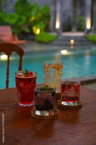 Fresh drink on the table with pool as background. Minuman dingin