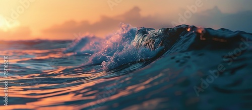 A blue ocean wave swirls and descends gracefully as the sun sets in the background, casting a warm golden light on the water.