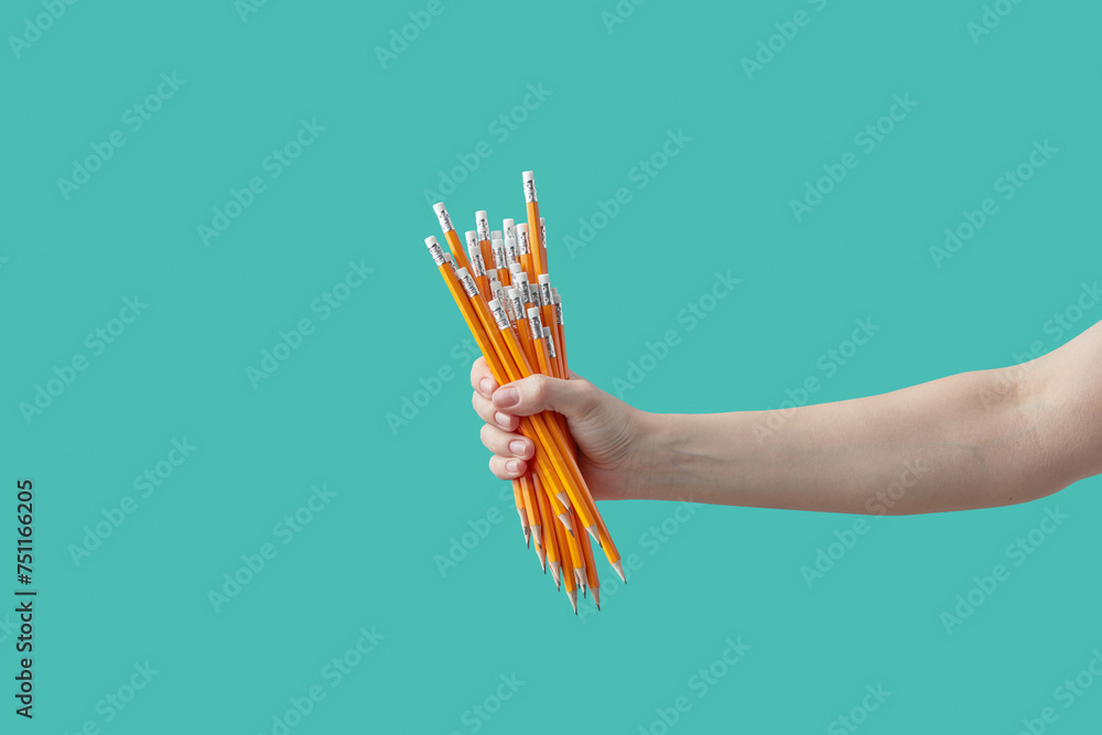 Woman's hand holding bundle of pencils. Woman's hand holding bundle of pencils.