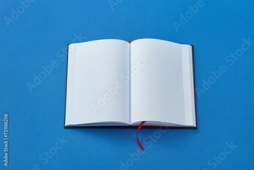 Open blank book on blue background. photo