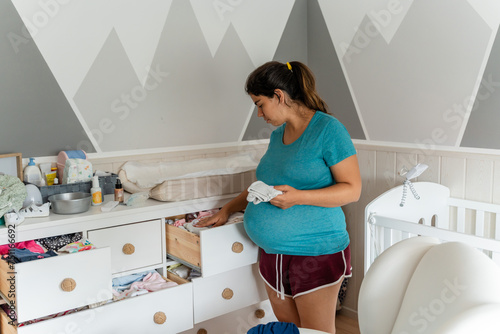 pregnant woman sorting clothes photo