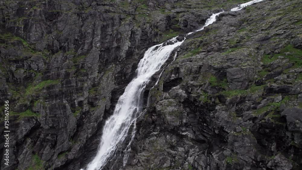 Aerial view of the Stigfossen waterfall in Norway as it crashes down the wild and craggy cliff face. Camera slowly pulls out from the waterfall. Patches of moss cover the dark rocks. Aerial view of the Stigfossen waterfall in Norway as it crashes down the wild and craggy cliff face. Camera slowly pulls out from the waterfall. Patches of moss cover the dark rocks.