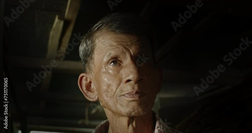 An Asian man who is an elderly worker live in a poor dark house. Used in film concepts, humanity, documentaries and others. photo