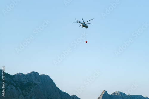 A firefighting helicopter flies over the mountains  photo