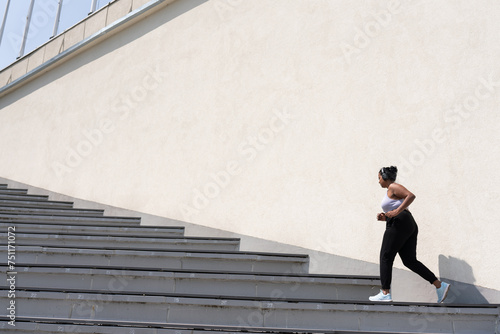 Plus Size Woman Running Up The Stairs Outdoors photo