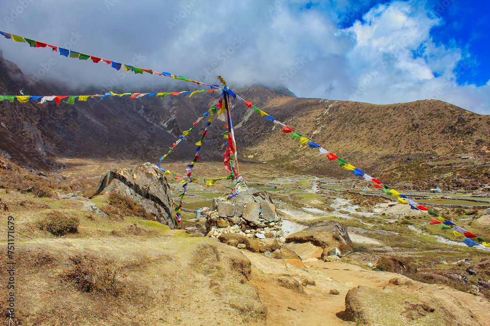 Tibetan Prayer flags near Machermo village at 4470 meters lies on the Dudh Kosi river on the Gokyo lake trails and offers accommodation for trekkers in the Khumbu, Nepal - obrazy, fototapety, plakaty 