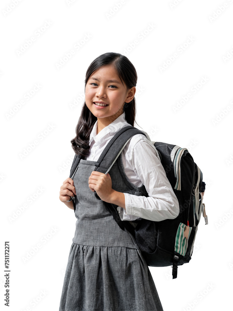 A young girl wearing a gray dress and a white shirt is holding a black backpack. She has dark hair and is smiling at the camera. A young girl wearing a gray dress and a white shirt is holding a black backpack. She has dark hair and is smiling at the camera.