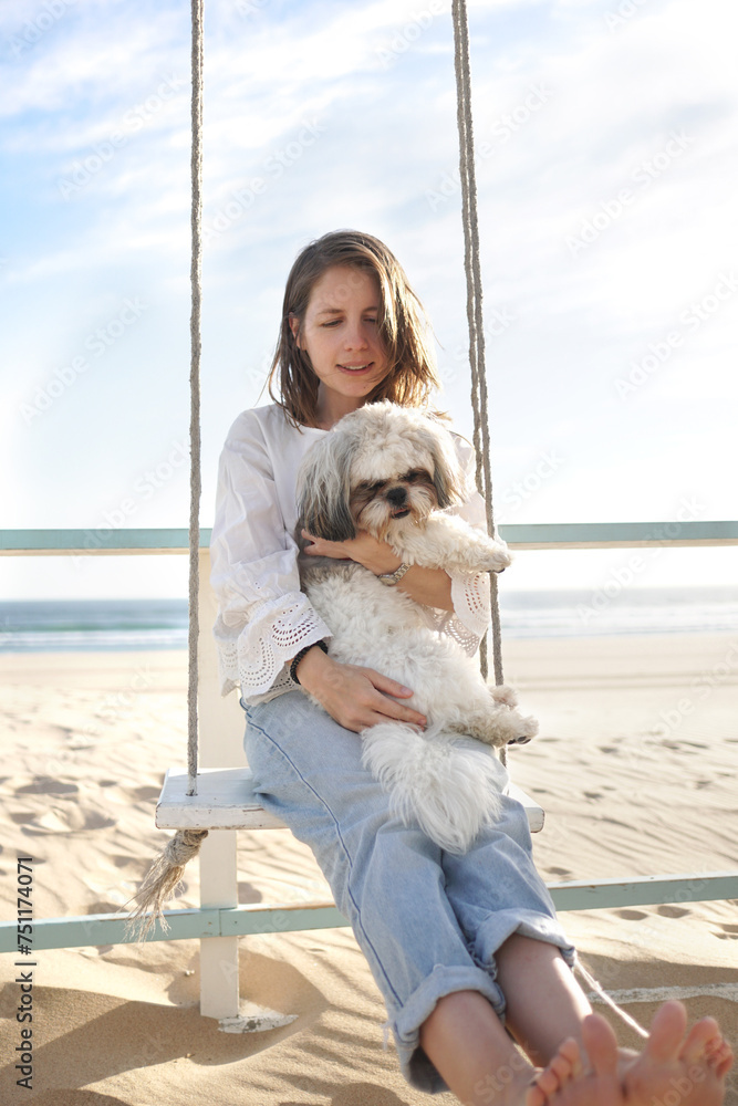 A young woman at a beach cafe hugs her dog on the oceanfront Stock ...