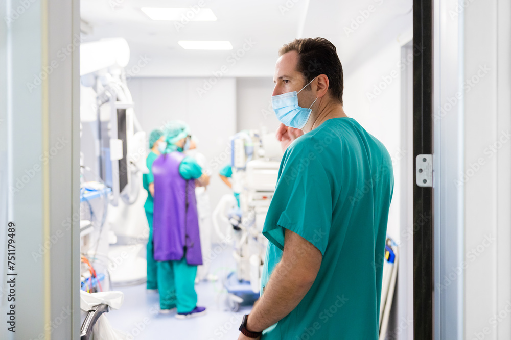Doctor in mask standing at hospital operating room door Doctor in mask standing at hospital operating room door