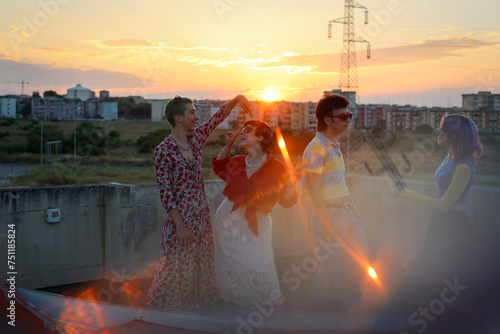 Young friends having fun at golden hour: colorful clothes and sunset photo