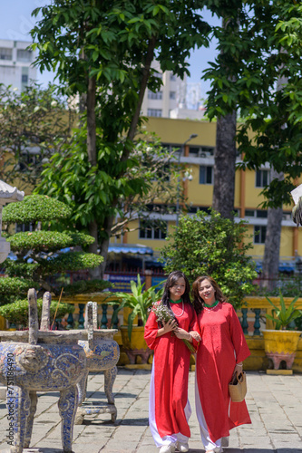 Portrait of Vietnamese mother and daughter in red Ao Dai Dress visit the pagoda on Tet holiday , Lunar new year