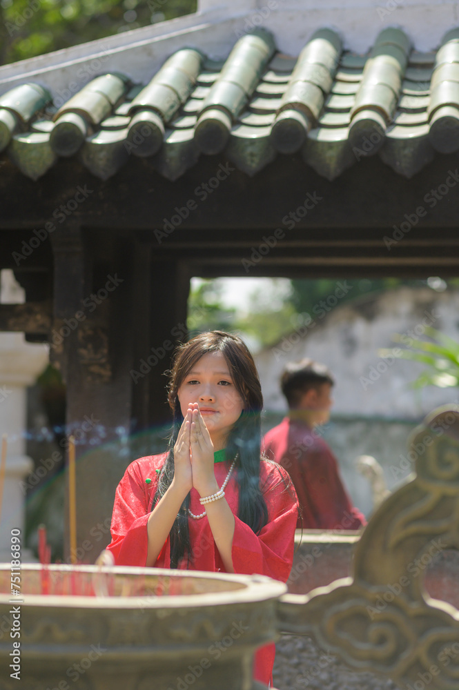 Portrait of teenager girl in Vietnamese Traditional Dress, Ao Dai in the temple 