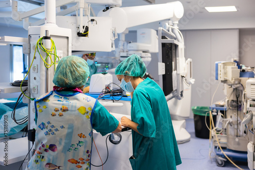 Group of doctors standing in modern hospital operating room photo