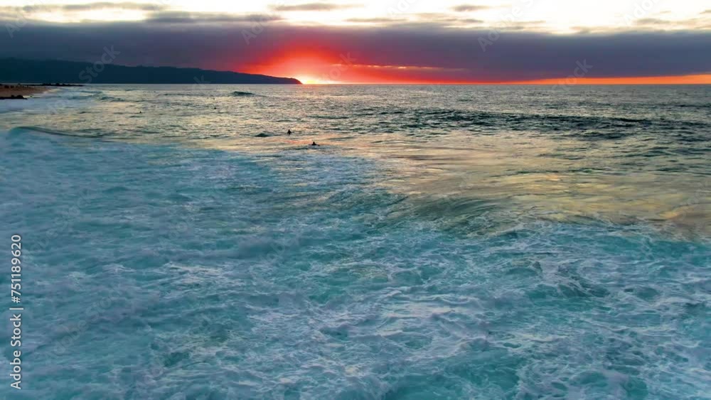 Silhouette of surfers in powerful Pacific ocean waves in Hawaii, aerial view Silhouette of surfers in powerful Pacific ocean waves in Hawaii, aerial view
