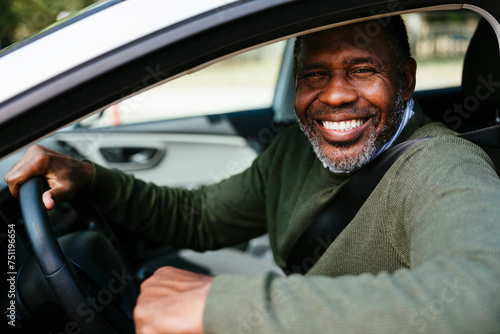 Happy mature man driving car photo