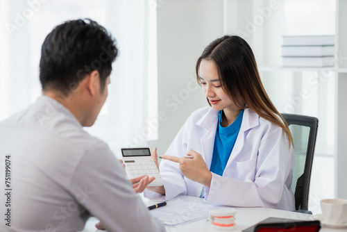 Female dentist counseling male patient at dental clinic office oral health care