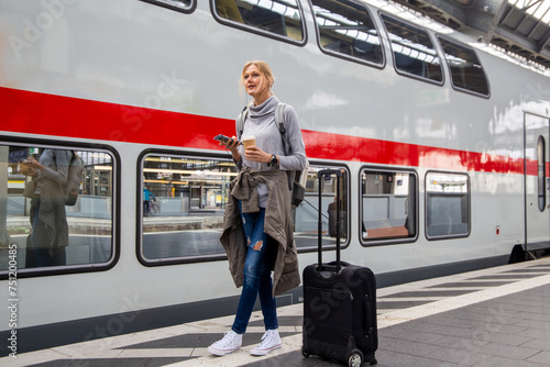 Junge Frau steht auf dem Bahngleis vor einem Zug