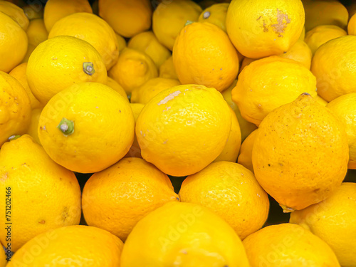 Closeup of vivid yellow lemons for sale in the market or mart. Fruit pattern for abstract background.
