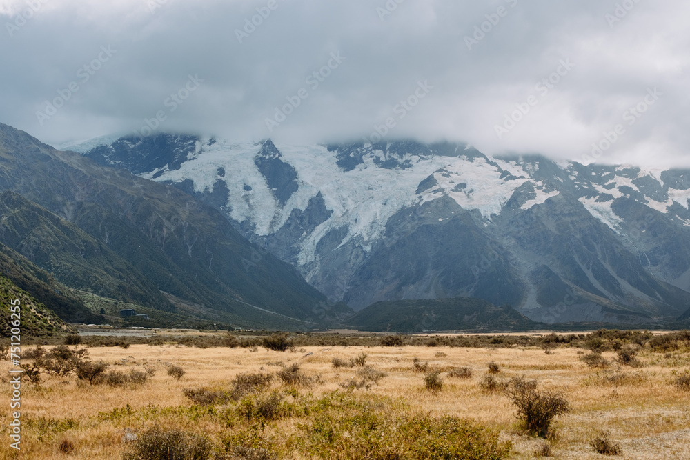 NZ snow and glacier covered mountain with dry grass below