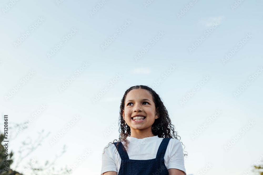 Candid portrait of curly haired girl outside at sunset. Candid portrait of curly haired girl outside at sunset.