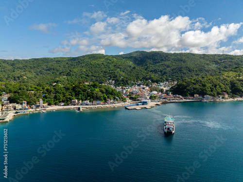 Coastline with port and city with houses. Ferry over the blue sea in Romblon Island. Romblon, Philippines.