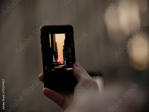 Manhattan henge hand holding a phone photo