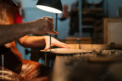 Male luthier creating design for violin photo