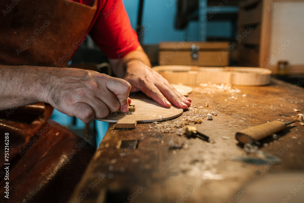 Craftsman planing instrument with plane making violin Craftsman planing instrument with plane making violin