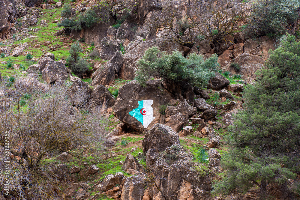 Low-angle view of the Algeria flag painted on a rock formation in the mountain. Low-angle view of the Algeria flag painted on a rock formation in the mountain.