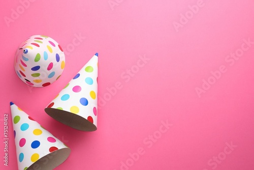 Beautiful party hats on pink background, top view. Space for text