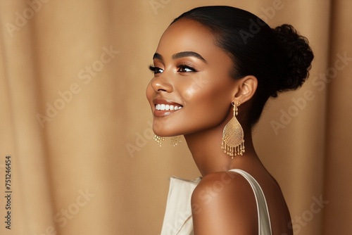 Elegant model portrait with gold earring smiling on studio background