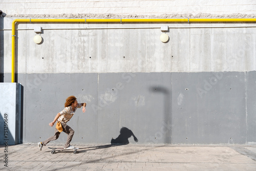 Energetic man skateboarding on street photo