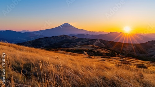 Breathtaking sunrise or setting sun in the mountains with blue clear sky with calm weather and volcano in the horizon