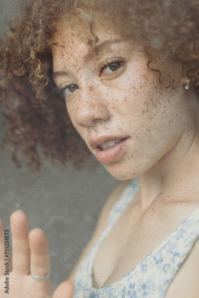 Girl with afro looking through a window Girl with afro looking through a window