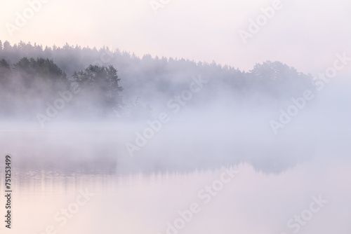 Dawn over a fog covered lake photo