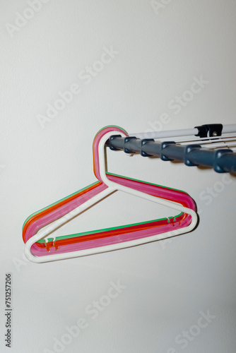 Colourful plastic cloth hangers hangin on a clotheshorse with flash photo