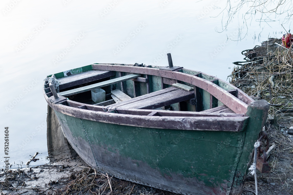 Abandoned wrecked boat stuck in dirt.