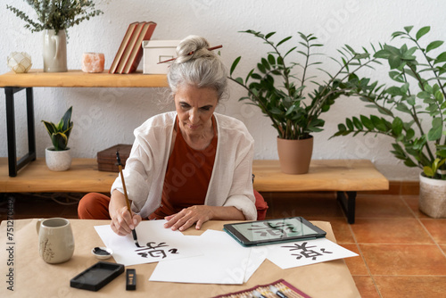 Retired woman painting sumie kanji 