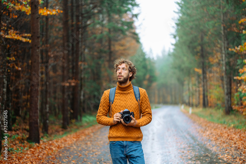 Man with vintage camera in the forest in autumn after the rain  photo