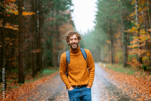 Cheerful man in the forest in autumn after the rain  photo